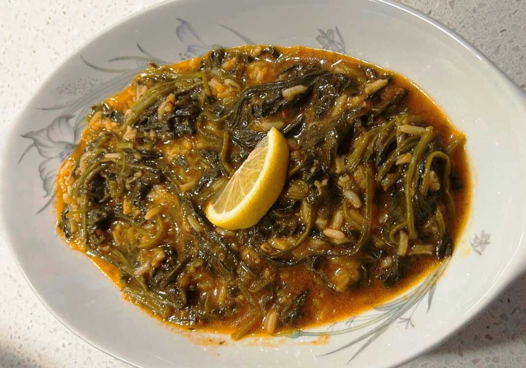 Πιάτο με ζεστό Σπανακόρυζο με έντονο πράσινο χρώμα και κόκκινη σάλτσα με φέτα στο πλάι (προαιρετικά)