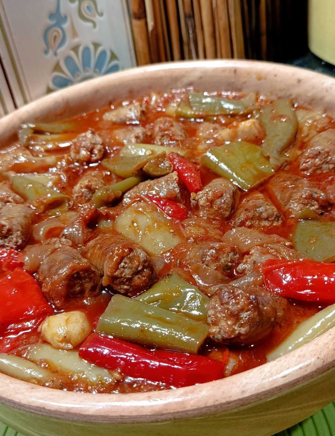 Παραδοσιακό Σπετσοφάι με χωριάτικα λουκάνικα και πλούσια κόκκινη σάλτσα.