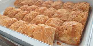 Κομμάτια από μεγάλη παραδοσιακή τυρόπιτα με χειροποίητο φύλλο και αφράτη γέμιση τυριών