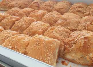 Κομμάτια από μεγάλη παραδοσιακή τυρόπιτα με χειροποίητο φύλλο και αφράτη γέμιση τυριών