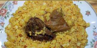 Ένα πιάτο με μοσχαράκι κοκκινιστό και ζυμαρικά (χυλοπιτάκι και κους κους), παχιά κόκκινη σάλτσα και πράσο, με τριμμένο τυρί από πάνω