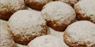 Μικρά χρυσαφένια μηλοπιτάκια σε σχήμα μισοφέγγαρου πασπαλισμένα με πυκνή ζάχαρη άχνη σε πιατέλα