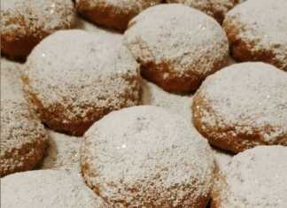 Μικρά χρυσαφένια μηλοπιτάκια σε σχήμα μισοφέγγαρου πασπαλισμένα με πυκνή ζάχαρη άχνη σε πιατέλα