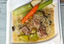 Χοιρινό με πρασοσέλινο με αυγολέμονο, σερβιρισμένο σε πιάτο με την παχύρρευστη λευκή σάλτσα