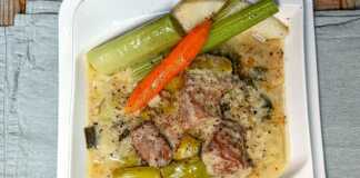 Χοιρινό με πρασοσέλινο με αυγολέμονο, σερβιρισμένο σε πιάτο με την παχύρρευστη λευκή σάλτσα