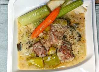 Χοιρινό με πρασοσέλινο με αυγολέμονο, σερβιρισμένο σε πιάτο με την παχύρρευστη λευκή σάλτσα