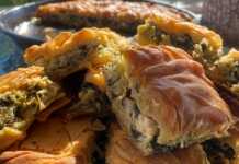 Σπιτική σπανακοτυρόπιτα με χρυσαφένια και τραγανή κρούστα, κομμένη σε κομμάτια και γεμάτη με πράσινη γέμιση