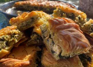 Σπιτική σπανακοτυρόπιτα με χρυσαφένια και τραγανή κρούστα, κομμένη σε κομμάτια και γεμάτη με πράσινη γέμιση