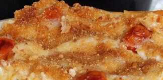 Ένα μεγάλο κομμάτι παστίτσιου σε πιάτο, με την πάνω λευκή κρούστα της μπεσαμέλ και τη γέμιση με τον κόκκινο κιμά μανιταριών.