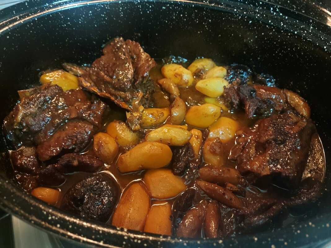 Μελένιο αγριογούρουνο μέσα σε γάστρα με πλούσια σκούρα σάλτσα, ολόκληρα σύκα, δαμάσκηνα και μικρές πατάτες baby.