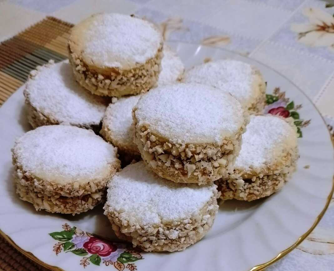 Δύο στρώσεις μπισκότων Αλφαχόρες με πλούσια γέμιση καραμέλας στο κέντρο και πασπαλισμένα με ζάχαρη άχνη.