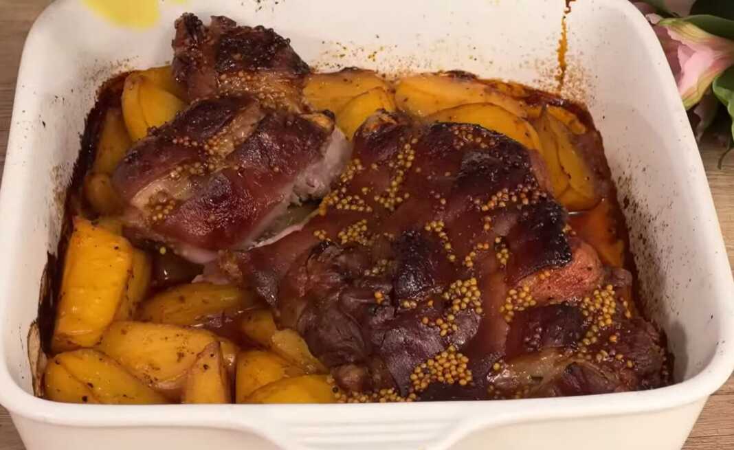 Ζουμερό χοιρινό κότσι με τραγανή χαραγμένη πέτσα πάνω σε ένα στρώμα από χρυσαφένιες πατάτες.