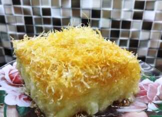 Ένα χρυσαφένιο ταψί με γαλακτομπούρεκο που έχει τραγανό φύλλο καταΐφι στην επιφάνεια και πλούσια κρέμα να ξεπροβάλλει.