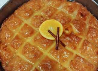 Κομμάτια από χρυσαφένιο γαλακτομπούρεκο σε πιατέλα, πασπαλισμένα με κανέλα, με την αφράτη κρέμα να φαίνεται στο εσωτερικό.