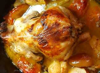 Ένα ολόκληρο ροδοκοκκινισμένο κοτόπουλο γεμιστό μέσα στη γάστρα περιτριγυρισμένο από μήλα, δαμάσκηνα και αρωματικά.