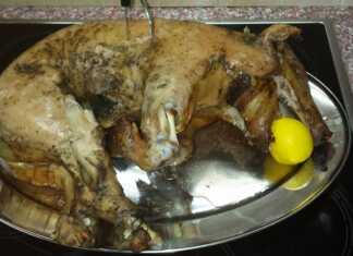 Ένα ολόκληρο ψημένο γουρουνάκι γάλακτος με χρυσαφένια τραγανή πέτσα, περιτριγυρισμένο από μελωμένες βουτυράτες πατάτες μέσα σε ένα μεγάλο ταψί.