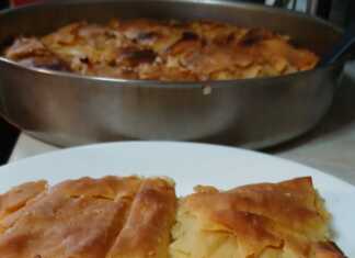 Μια λαχταριστή κασερόπιτα με χρυσάφι χωριάτικο φύλλο, κομμένη σε κομμάτια που αποκαλύπτουν την πλούσια κρέμα τυριών.