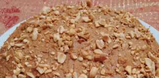 αφράτο κέικ φιστικοβούτυρου, καλυμμένο με μία στρώση φιστικοβούτυρο και διακοσμημένο με ολόκληρα φιστίκια αράπικα.