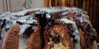 Ένα ψηλό κέικ πορτοκαλιού καλυμμένο με πλούσιο γλάσο μαύρης και λευκής σοκολάτας, διακοσμημένο για το χριστουγεννιάτικο τραπέζι.