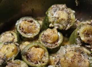 Κολοκυθάκια γεμιστά με κιμά και ρύζι, σερβιρισμένα σε πιάτο, καλυμμένα με λαχταριστή σάλτσα αυγολέμονο και πασπαλισμένα με άνηθο.