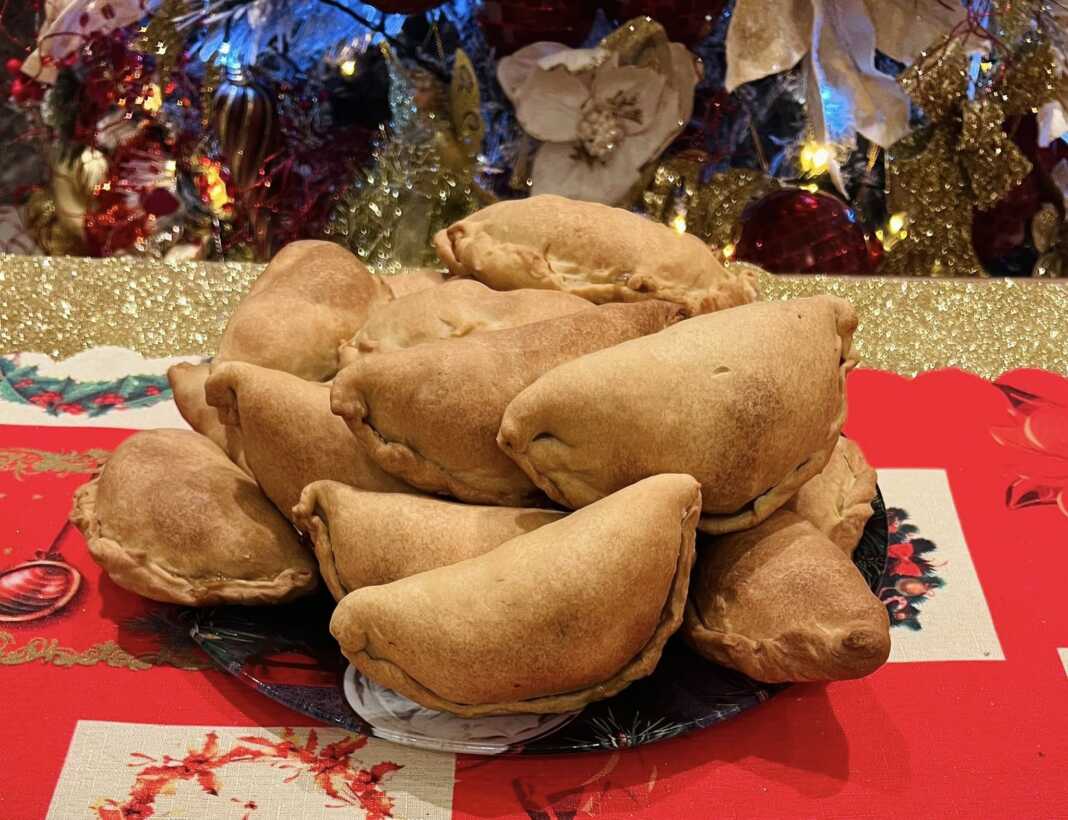 Παραδοσιακές κυπριακές κολοκοτές (μισοφέγγαρα) με χρυσαφένιο χρώμα, τοποθετημένες σε ψάθινο πανέρι.