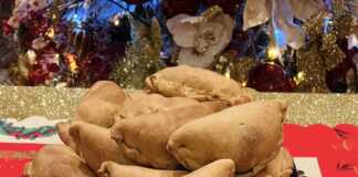 Παραδοσιακές κυπριακές κολοκοτές (μισοφέγγαρα) με χρυσαφένιο χρώμα, τοποθετημένες σε ψάθινο πανέρι.