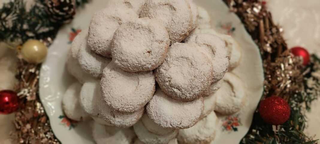 Κουραμπιέδες σε σχήμα μπαλίτσας πασπαλισμένοι με άφθονη άχνη ζάχαρη, δημιουργώντας ένα εφέ «χιονιού».