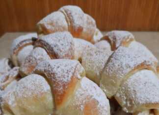 Πιάτο με μικρά χρυσαφένια κρουασανάκια με γέμιση, πασπαλισμένα με ζάχαρη άχνη.