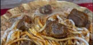 Ένα πιάτο με κοκκινιστό κατσικάκι και μακαρόνια βρασμένα στη σάλτσα του, πασπαλισμένα με τριμμένο ανθότυρο.