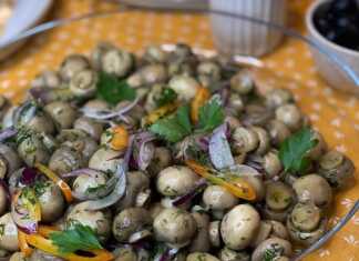 Ένα γυάλινο ταψι γεμάτο με μικρά ολόκληρα μανιτάρια (π.χ. champignon) τουρσί με ψιλοκομμένα κρεμμύδια και λάδι.