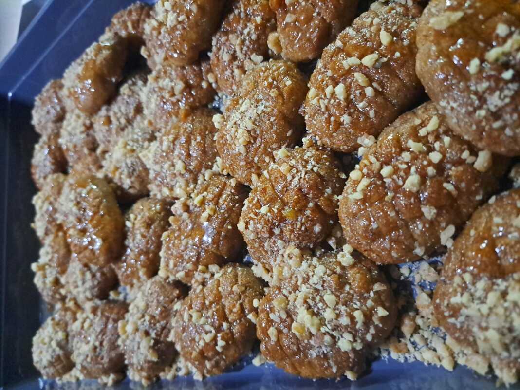 Πιατέλα με μελωμένα μελομακάρονα πασπαλισμένα με μπόλικο τριμμένο καρύδι.