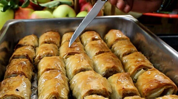 Ρολάκια μπακλαβά γεμισμένα με μήλο και καρύδι, λουσμένα με σιρόπι και ροδισμένα στο φούρνο.