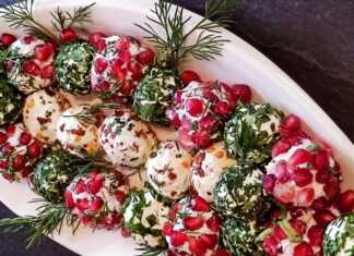 Πολύχρωμες μπαλίτσες τυριού με ρόδι και ξηρούς καρπούς δίπλα σε τυρένια δεντράκια στολισμένα με πάπρικα.