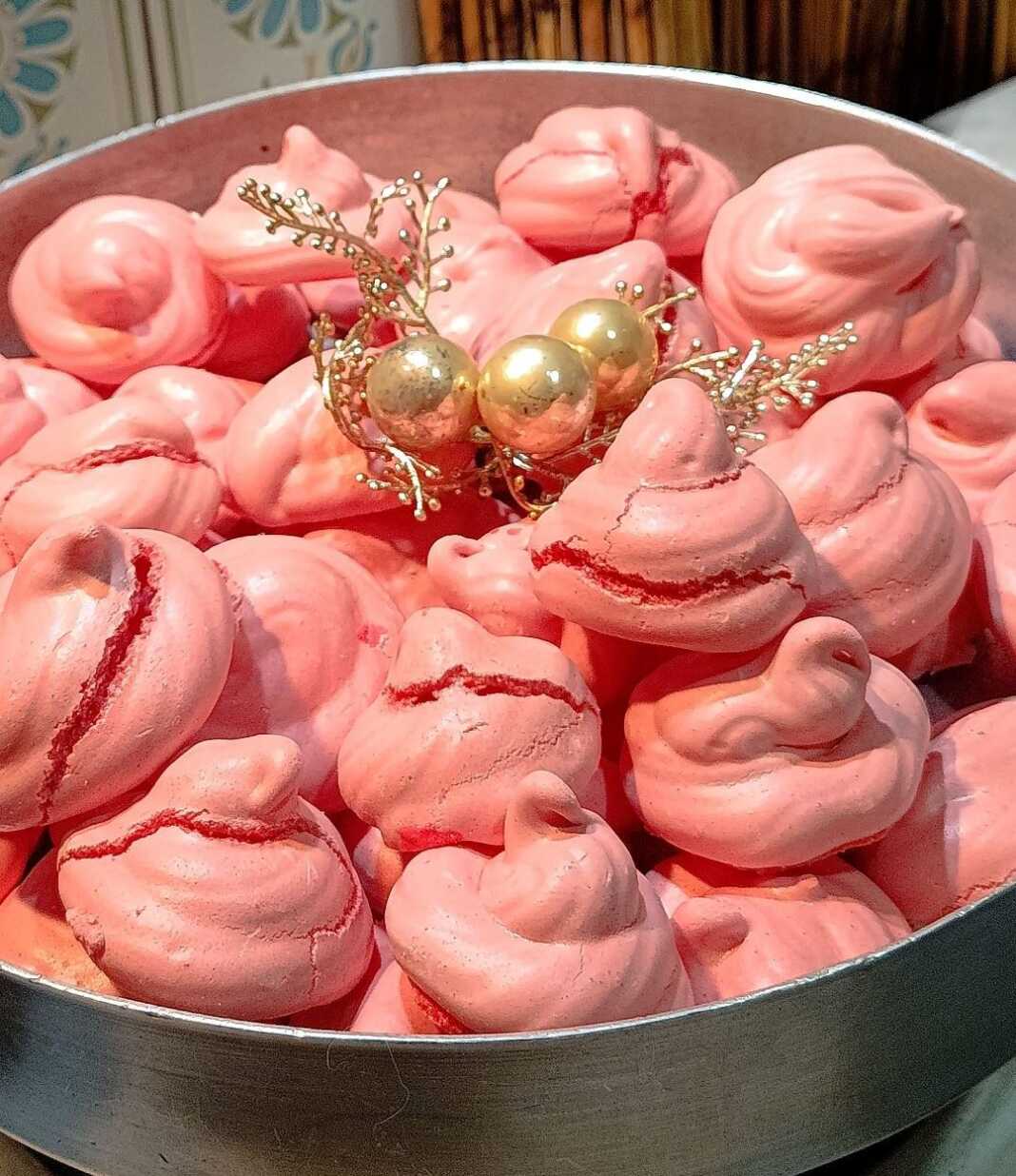 Πολλοί μικροί ροζ μπεζέδες με ραβδώσεις από κορνέ τοποθετημένοι πάνω σε λαδόκολλα μέσα σε ταψί