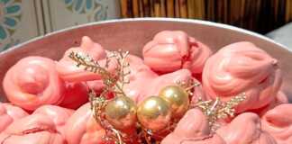 Πολλοί μικροί ροζ μπεζέδες με ραβδώσεις από κορνέ τοποθετημένοι πάνω σε λαδόκολλα μέσα σε ταψί