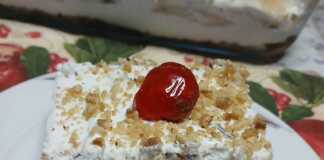 Γλυκό ταψιού πολυεπίπεδο με σοκολάτα, σαντιγί και καβουρδισμένα φουντούκια στην επιφάνεια.