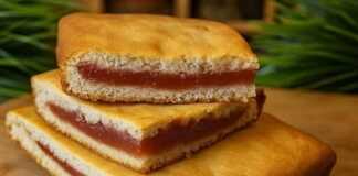 Κέικ γεμιστό με κόκκινη μαρμελάδα (βαρένιε), κομμένο σε κομμάτια και πασπαλισμένο με ζάχαρη άχνη.