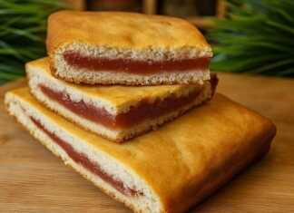 Κέικ γεμιστό με κόκκινη μαρμελάδα (βαρένιε), κομμένο σε κομμάτια και πασπαλισμένο με ζάχαρη άχνη.