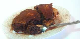 Ζεστή σοκολατένια πίτα με αχλάδια, κομμένη σε μερίδες σε πιάτο, με το κέντρο της να είναι ακόμα ρευστό και σοκολατένιο, δίπλα σε μια μπάλα παγωτό.