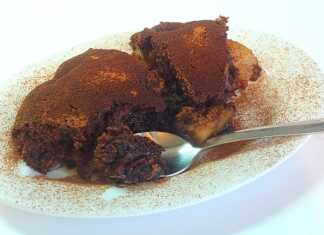 Ζεστή σοκολατένια πίτα με αχλάδια, κομμένη σε μερίδες σε πιάτο, με το κέντρο της να είναι ακόμα ρευστό και σοκολατένιο, δίπλα σε μια μπάλα παγωτό.