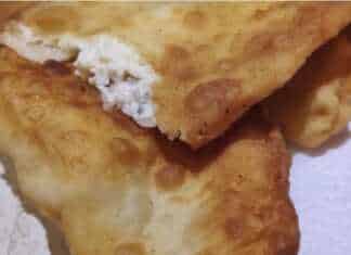 χρυσαφένιες τηγανητές πίτες με τυρί σε πιατέλα, με μία κομμένη που δείχνει τη λιωμένη γέμιση φέτας.