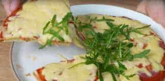 Μια λαχταριστή πίτσα με λιωμένο τυρί και σαλάμι μέσα σε ένα αντικολλητικό τηγάνι.