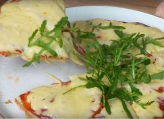 Μια λαχταριστή πίτσα με λιωμένο τυρί και σαλάμι μέσα σε ένα αντικολλητικό τηγάνι.