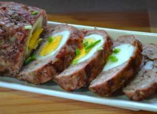 Ένα λαχταριστό ρολό κιμά κομμένο σε φέτες, με ένα ολόκληρο βραστό αυγό στο κέντρο, σερβιρισμένο σε πιατέλα.