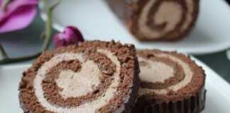 Ένα ρολό παντεσπάνι σοκολάτας τυλιγμένο, καλυμμένο με γυαλιστερό γλάσο σοκολάτας, με την κρέμα να φαίνεται στο εσωτερικό του ρολού.