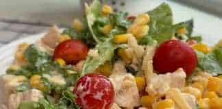 Μια δροσερή σαλάτα με κοτόπουλο, ντοματίνια, καλαμπόκι και μια κρεμώδη λευκή σάλτσα σε ένα μπολ.