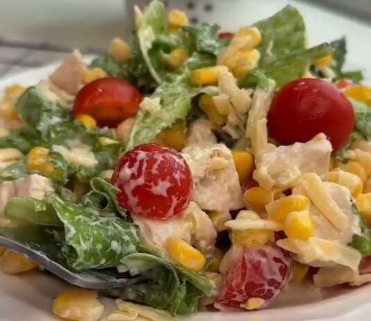 Μια δροσερή σαλάτα με κοτόπουλο, ντοματίνια, καλαμπόκι και μια κρεμώδη λευκή σάλτσα σε ένα μπολ.