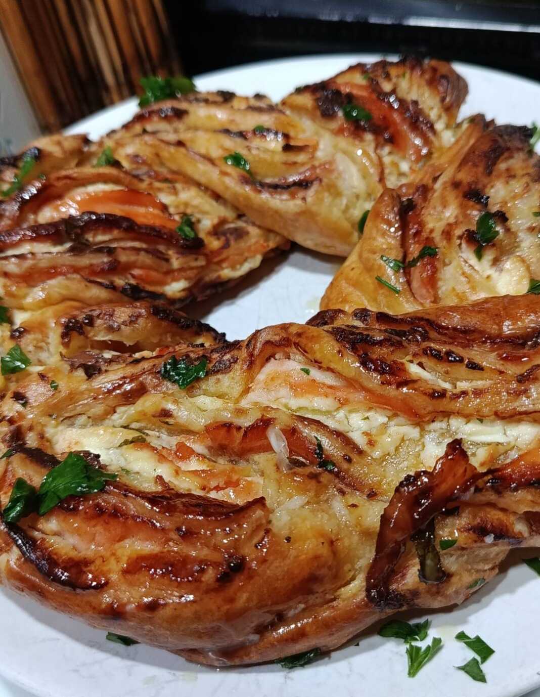 Μια χρυσαφένια σφολιατοκουλούρα με καπνιστό σολομό και τυρί κρέμα, αλειμμένη με βούτυρο και σκόρδο.