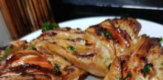 Μια χρυσαφένια σφολιατοκουλούρα με καπνιστό σολομό και τυρί κρέμα, αλειμμένη με βούτυρο και σκόρδο.