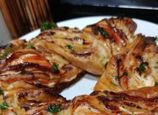 Μια χρυσαφένια σφολιατοκουλούρα με καπνιστό σολομό και τυρί κρέμα, αλειμμένη με βούτυρο και σκόρδο.